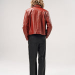 Person wearing a red leather jacket and black pants on a white background